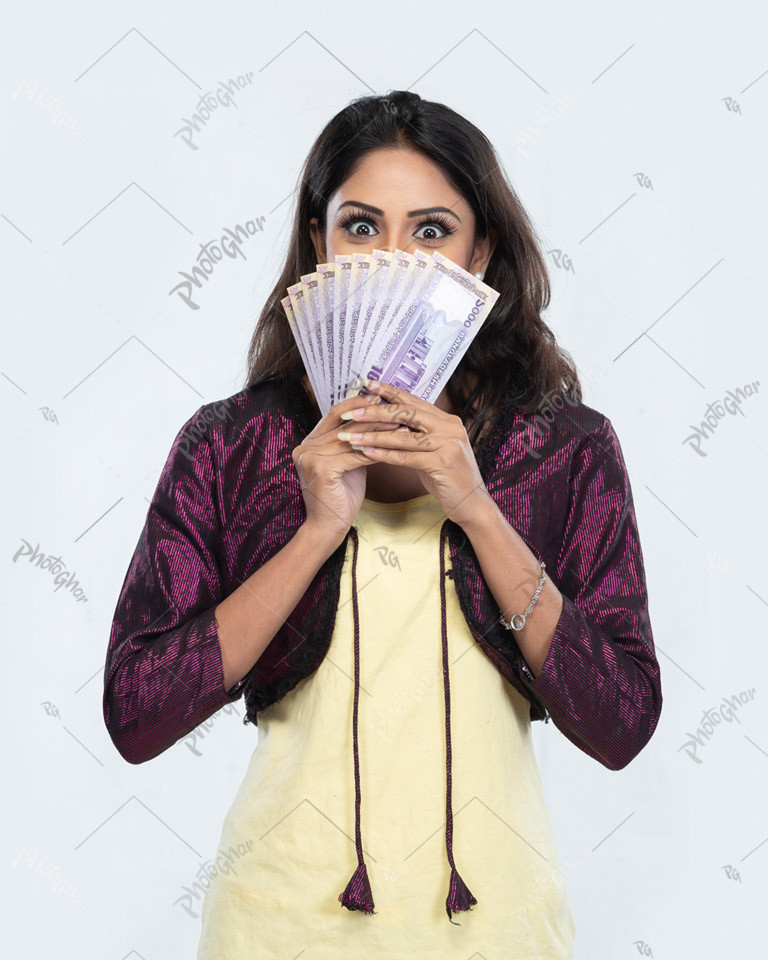 Young woman covering her mouth with money