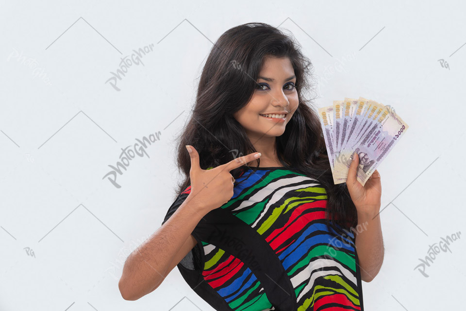 joyful teenage girl pointing finger at money