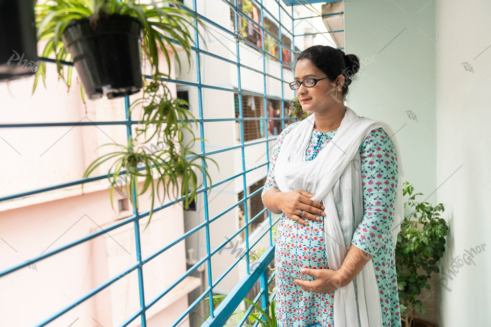 soon-to-be mom standing at the home balcony