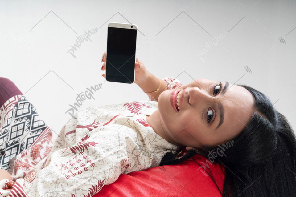 young woman showing smartphone empty screen